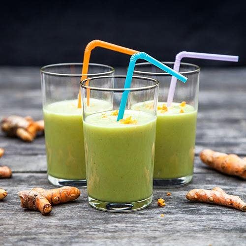 Avokado och banansmoothie med färsk gurkmeja