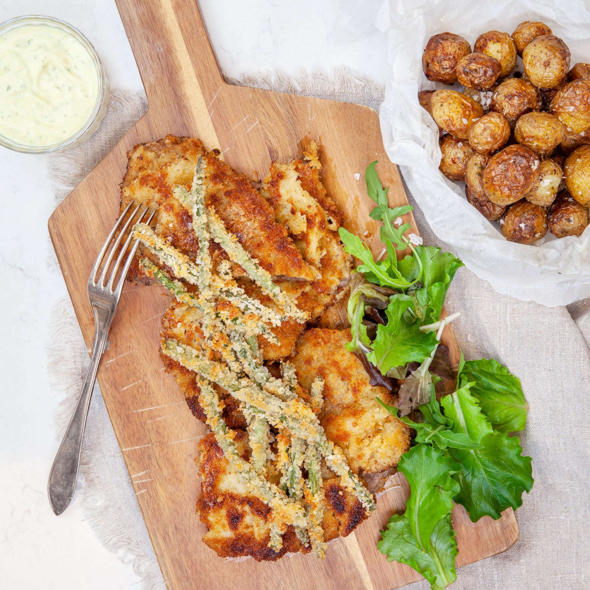 Panerad kalvschnitzel med frasiga haricots verts, ramslökshollandaise och rostad småpotatis