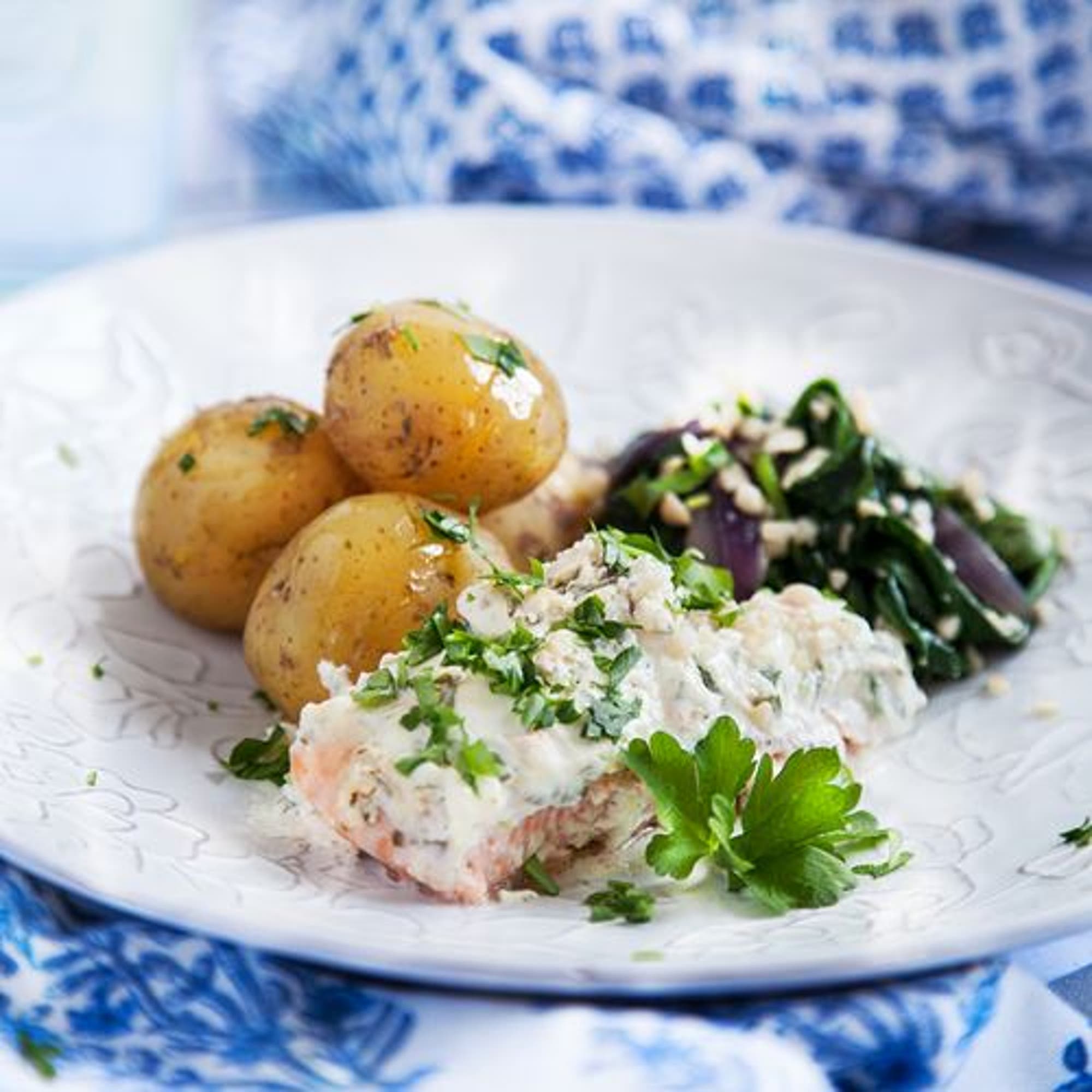 Citron- och färskostbakad lax med smörstekt spenat och mandel