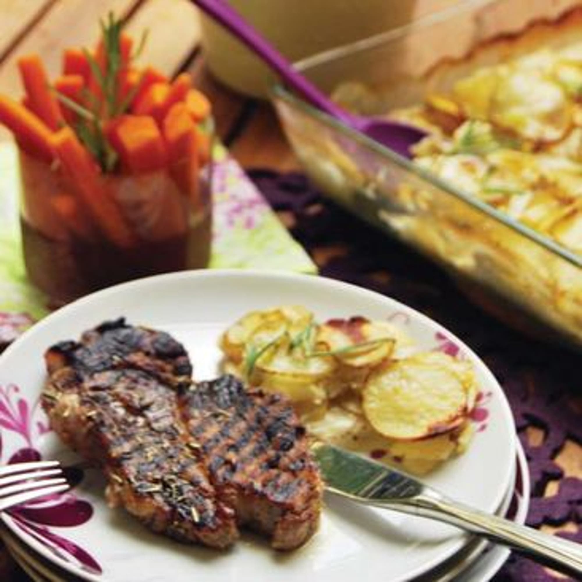 Grillad fläskkarré med potatis- och blomkålsgratäng och persikosallad