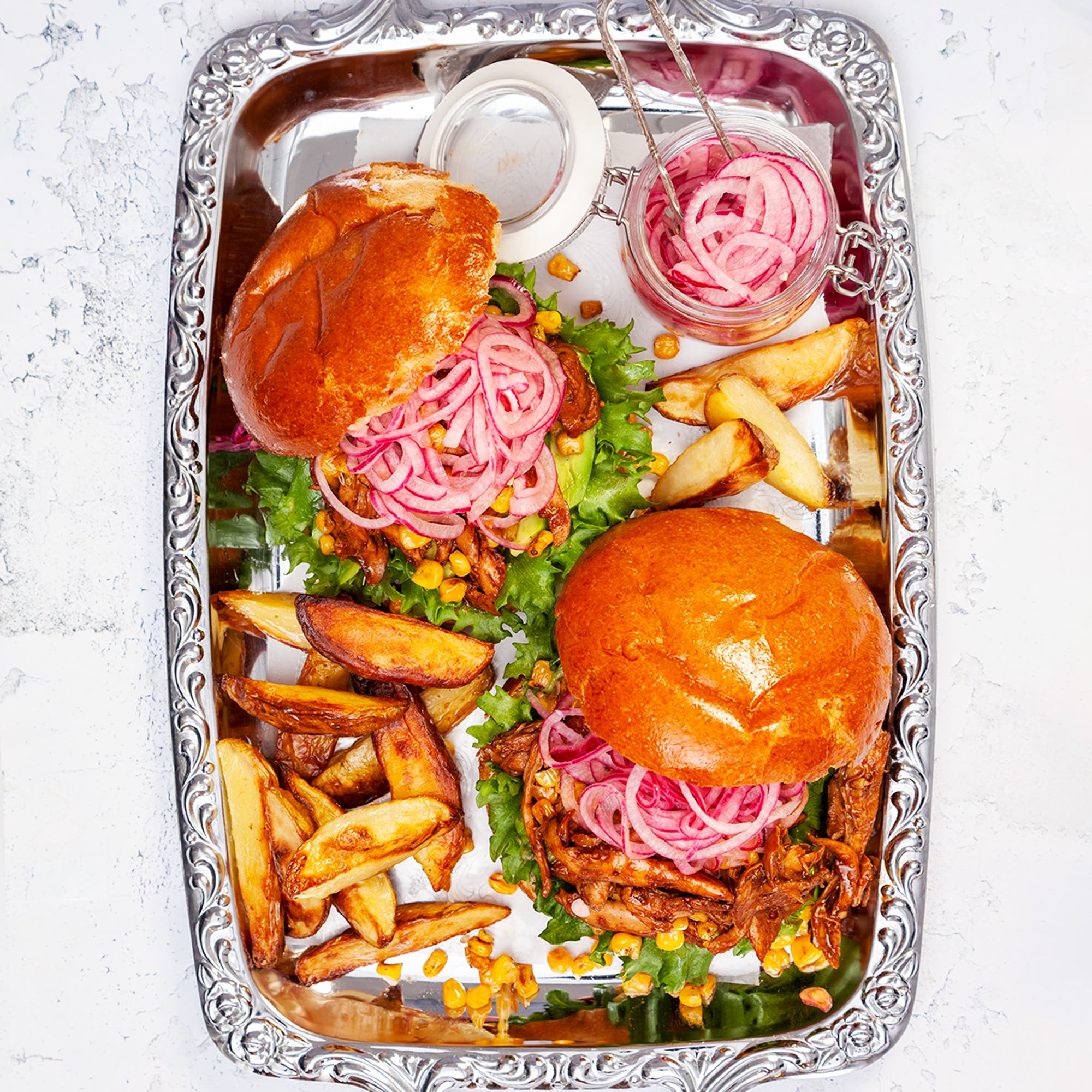 Pulled chicken burger med avokado, rostad majs och picklad lök