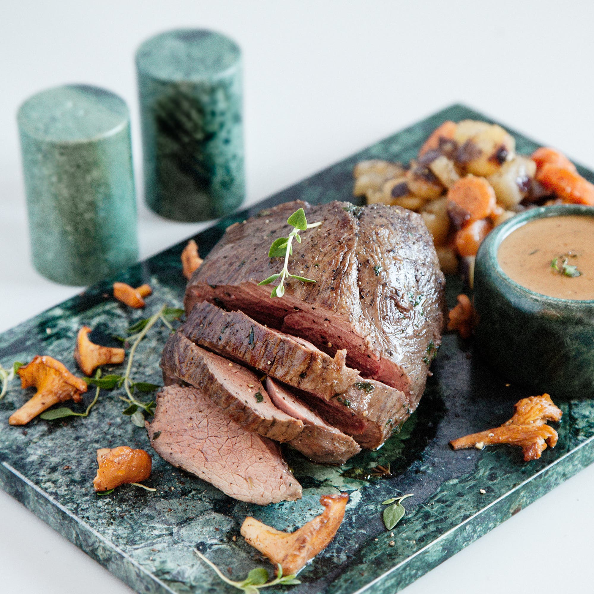 Ugnsstekt dovhjort med kål- och rotfruktspytt, svart vitlökssås och smörstekta kantareller