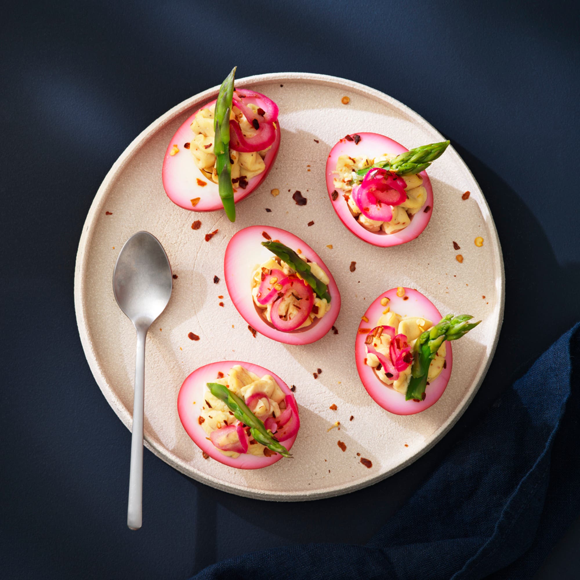 Rosa deviled egg med picklad lök och sparris