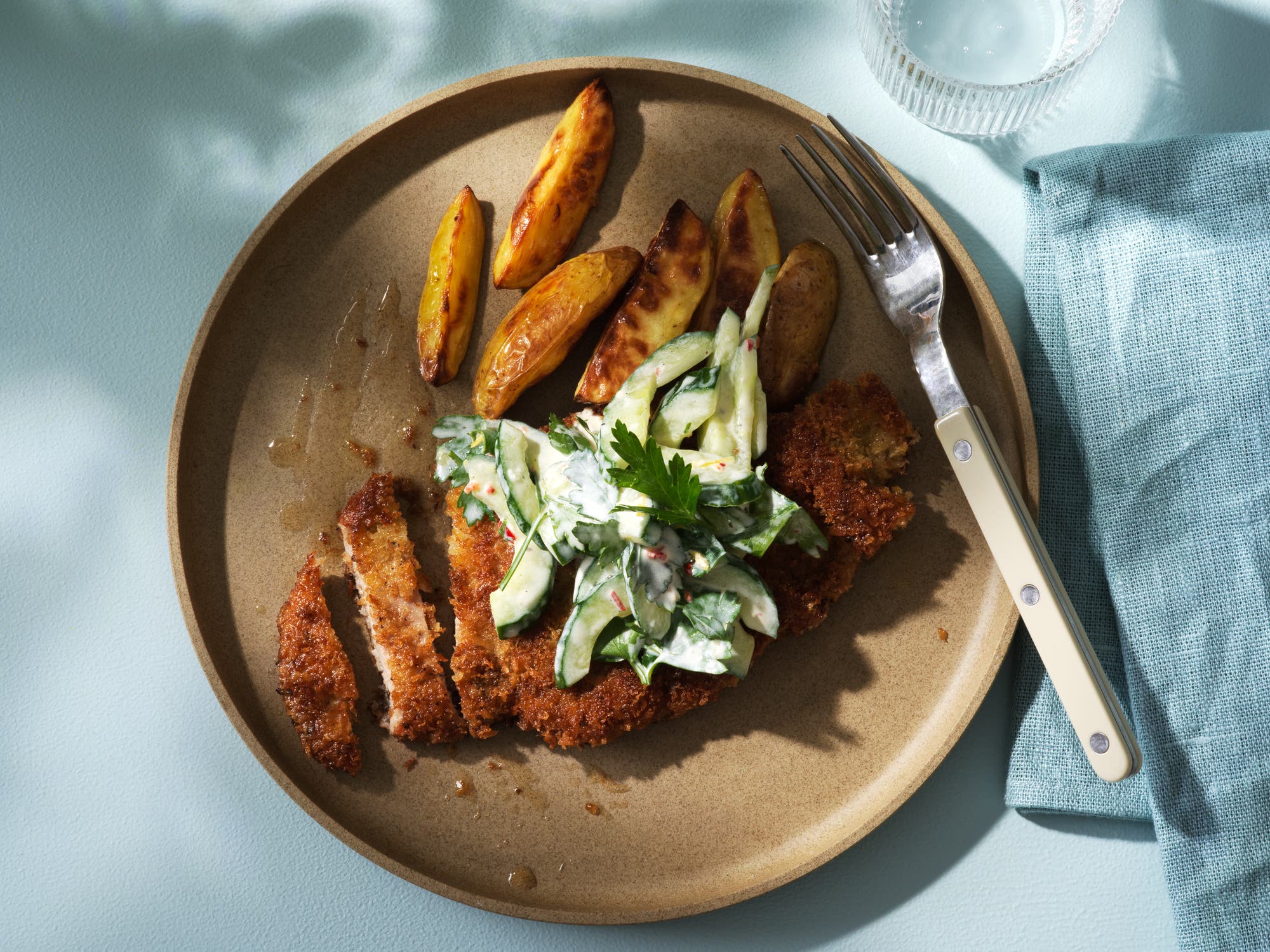 Krispig schnitzel med krämig gurksallad och klyftpotatis