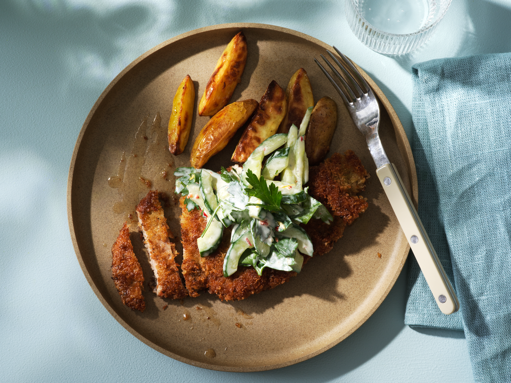 Krispig schnitzel med krämig gurksallad och klyftpotatis